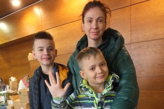 Ukrajinská lekára Katarína (38) z Kyjeva s deťmi Hrehorijom (12) a Tarasom (9) vypomáha pri triedení materiálu pre utečencov priamo pod sobášnou miestnosťou.
