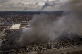 Po bombardovaní v Irpine na predmestí Kyjeva na Ukrajine horela továreň a obchod.