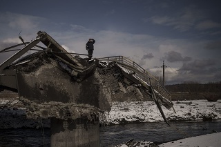Muž stojí na zničenom moste v meste Irpiň nachádzajúcom sa neďaleko Kyjeva počas ruskej invázie na Ukrajine.