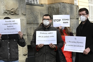 Zamestnanci súdov držia v rukách transparenty počas protestu proti súdnej mape.