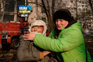 Ženy plačú pred zničeným bytovým domom po bombovom útoku v obytnej štvrti v Kyjeve.