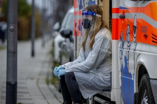 Zdravotná pracovníčka pred mobilnou testovacou dodávkou vo Frankfurte.