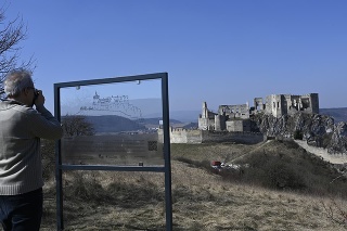 Historik Martin Bóna si fotografuje sklenený panel so siluetou Beckovského hradu.