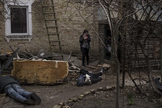 Na snímke Ira Gavriľuková nesie svoju mačku, keď kráča vedľa mŕtvol svojho manžela a svojho brata, ktorých zabili v meste Buča.