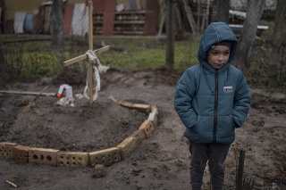 Na snímke je 6-ročný chlapec Vlad, ktorý stojí vedľa hrobu svojej matky. Počas vojny na Ukrajine zomrela od hladu.