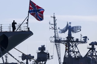 Ruský námorník salutuje na prove raketového krížnika Moskva (vľavo), kýmsa posádka ruskej hliadkovej lode Pitliviy (vpravo) pripravuje sa ukotviť plavidlo v Sevastopole (archívne foto).