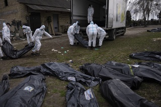Buča, Ukrajina: Pracovníci nakladajú telá obetí na nákladné auto.