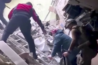 Na snímke z videa z 1. mája 2022 ľudia preliezajú ruiny v oceliarni Azovstaľ v Mariupoli.