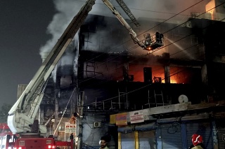 Hasiči sa snažia uhasiť požiar štvorposchodovej budovy v západnej časti indického Naí Dillí.