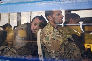 Ukrajinskí vojaci, ktorí niekoľko týždňov odolávali útokom ruských síl v oceliarniach Azovstaľ, sedia v autobuse po evakuácii.