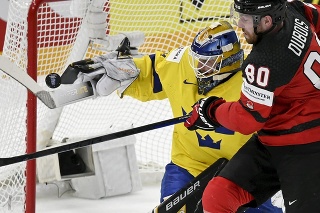 Švédsky brankár Linus Ullmark(vľavo) v súboji s Kanaďanom Pierreom-Lucom Duboisom v zápase štvrťfinále Švédsko - Kanada.