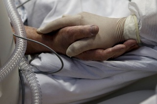 COVID-19 v Taliansku: Zdravotná sestra drží za ruku pacienta s ochorením Covid-19 na Jiske v nemocnici v Ríme 20. októbra 2020.