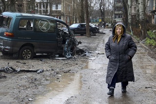 Obyvateľka Mariupoľu prechádza okolo poškodeného vozidla označeného písmenom Z, ktoré sa stalo symbolom ruskej armády
