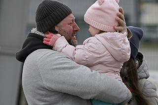 Otec objíma svoju dcéru, keď sa rodina zjednotila po úteku pred konfliktom na Ukrajine na hraničnom priechode Medyka v Poľsku.