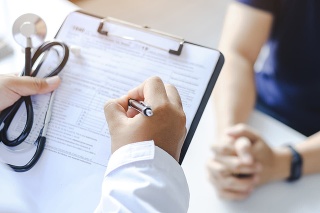 Close-up of a male doctor hand hold a silver pen and showing pad in hospital. Doctor giving prescription to the patient and filling up medical form at a clipboard
