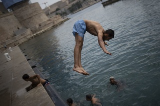  Muž skáče do vody počas horúčav v Marseille.