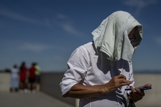 Muž si zakrýva hlavu pred slnkom počas horúceho dňa v španielskom Madride, v piatok 10. júna 2022.