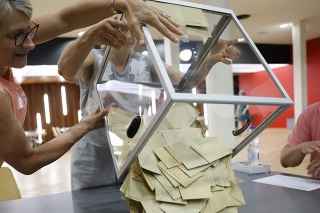 Dobrovoľníci začínajú s počítaním hlasovacích lístkov vo volebnej miestnosti v nedeľu 19. júna 2022 v Bischeime pri Štrasburgu vo východnom Francúzsku.