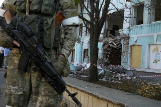 Ruský vojak stojí pri zničenej budove po ostreľovaní v Donecku.