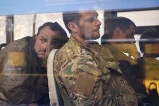 Ukrajinskí vojaci, ktorí niekoľko týždňov odolávali útokom ruských síl v oceliarniach Azovstaľ, sedia v autobuse po evakuácii.