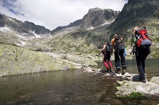 Group of people crossing mountain pond in Tatra Mountains, Slovakia