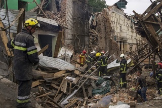 Záchranári prehľadávajú trosky budov po ruskom raketovom útoku v meste Čuhujiv.