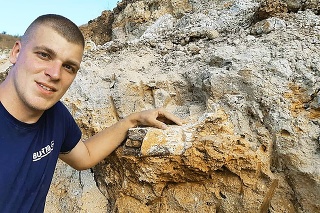 Mladý paleontológ pri časti kosti nosorožca
