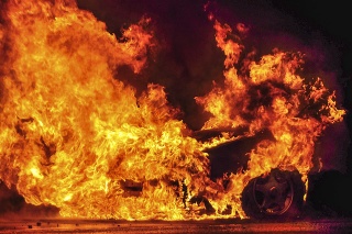 Shot of a roadside care fire at night.