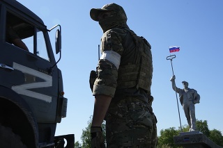 Ruský vojak drží strž v Mariupole. 
