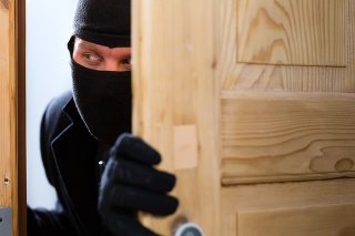 Security - disguised burglar breaking in an apartment or office to steal something