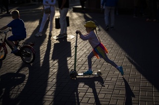Dievča jazdí na kolobežke na ulici v centre Kyjeva na Ukrajine.