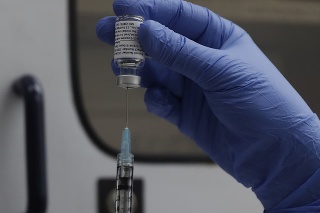 Vedec naťahuje injekčnou striekačkou z ampulky vakcínu proti ochoreniu COVID-19 od americkej farmaceutickej spoločnosti Novavax.