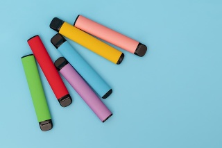 Set of colorful disposable electronic cigarettes on a blue background. The concept of modern smoking
