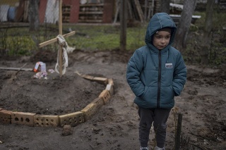Na snímke je 6-ročný chlapec Vlad, ktorý stojí vedľa hrobu svojej matky. Počas vojny na Ukrajine zomrela od hladu.