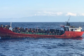 Lodi neschopnej plavby so 400 migrantmi pomáhajú dostať sa do prístavu.