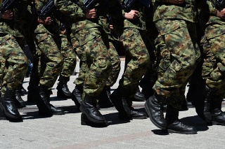 Army military soldiers marching in a parade outdoors.