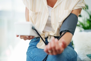 Cropped shot of a woman checking her blood pressure at home