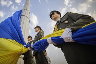  Príslušníci čestnej stráže držia ukrajinskú vlajku pri príležitosti osláv Dňa štátnej vlajky Ukrajiny v Kyjeve v utorok 23. augusta 2022.
