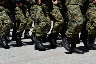 Army military soldiers marching in a parade outdoors.