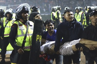 Fanúšikovia nesú zraneného muža po potýčkach na futbalovom zápase.