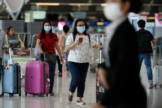 Bangkok, Thailand - February 18, 2020: Air travelers wearing masks walk through departures hall of Suvarnabhumi Airport. Thailand has been assessed as a country at risk of Covid-19 outside of China.