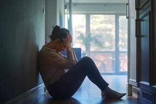 Sad Young Woman Sitting on the Floor In the Hallway of Her Appartment, Covering Face with Hands. Atmosphere of Depression, Trouble in Relationship, Death in the Family. Dramatic Bad News Moment