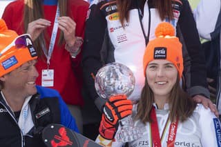 Na snímke vpravo slovenská lyžiarka Petra Vlhová s pohárovou trofejou a medailou víťazky v slalome žien po finále Svetového pohára a vľavo jej tréner Mauro Pini.