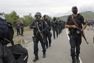Kosovskí policajti kráčajú, aby nahradili svojich kolegov na hraničnom priechode Jarinje na severe Kosova.