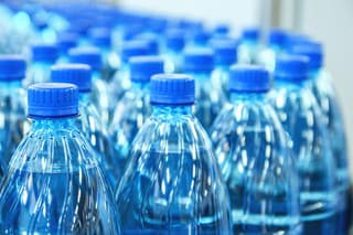 Closeup on mineral water green bottles in raw and lines