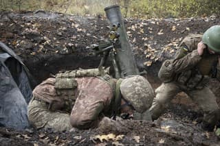 Ukrajinskí vojaci strieľajú z mínometu na frontovej línii neďaleko kľúčového mesta Bachmut.