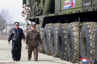 Severokórejský vodca Kim Čong-un, uprostred vľavo, prechádza okolo medzikontinentálnej balistickej rakety Hwasong-17 (ICBM) na odpaľovacej jednotke na neznámom mieste v Severnej Kórei 24. 2022.