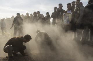 Sýrski Kurdi pochovávajú mŕtvych po tureckom útoku.