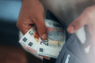 Young man holding in hands wallet with euro money. Horizontal composition.