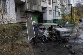 Miestna obyvateľka odstraňuje materiálne škody po raketovom útoku ruskej armády v Chersone vo štvrtok 24. novembra 2022